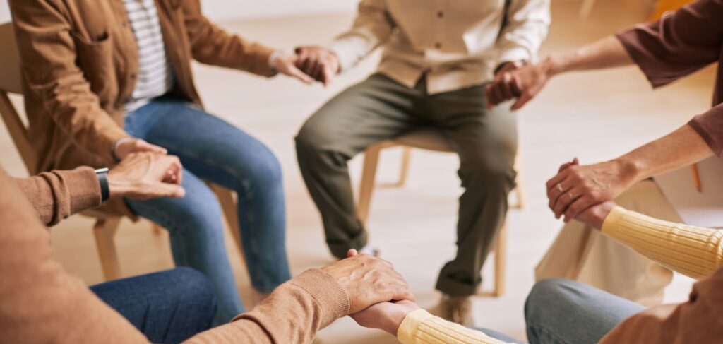 People holding hands in a  group therapy session at Cigna rehab in Tennessee.